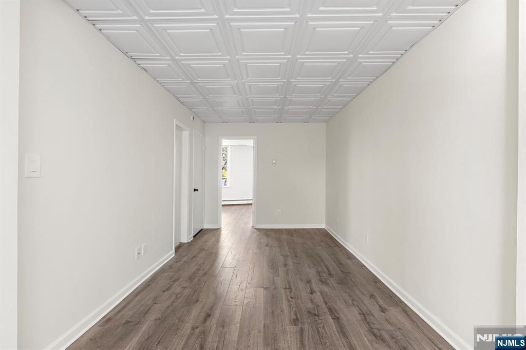 1534 Paterson Plank Road, Unit 2 Secaucus, NJ 07094 - Photo 5 of 17 a view of a room with wooden floor and white walls
