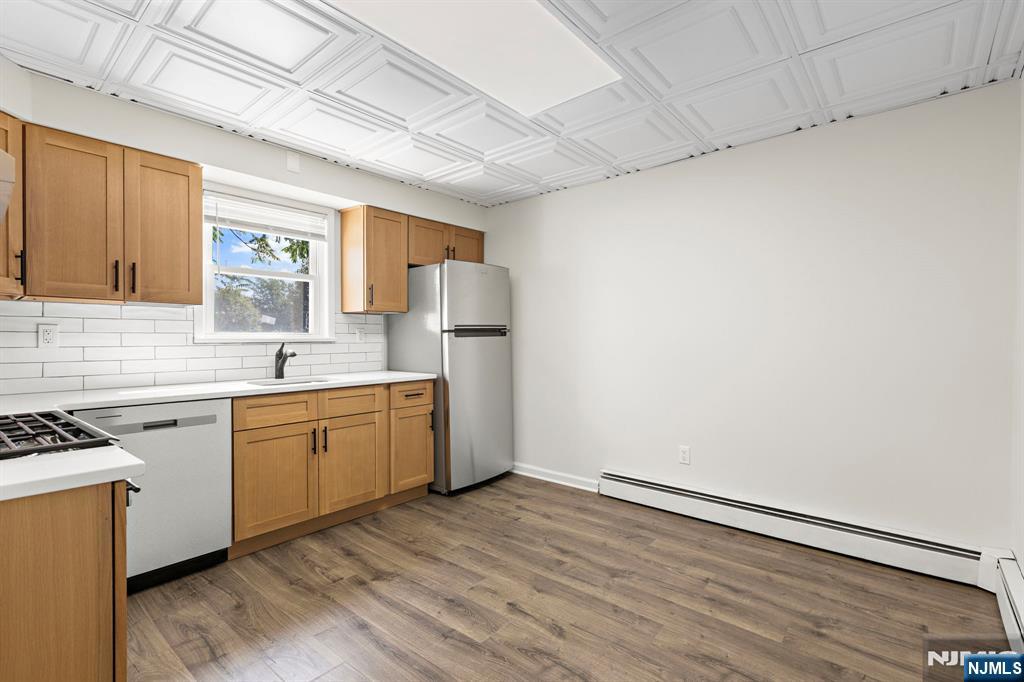 1534 Paterson Plank Road, Unit 2 Secaucus, NJ 07094 - Photo 6 of 17 a kitchen with granite countertop a sink cabinets stainless steel appliances and a window