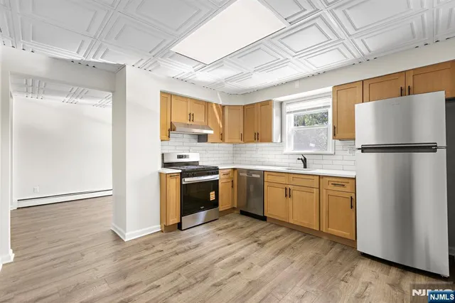 a kitchen with granite countertop a refrigerator stove top oven and sink