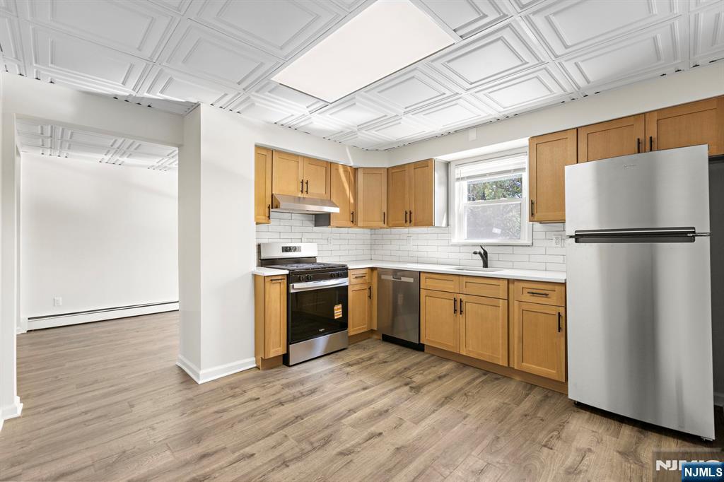 1534 Paterson Plank Road, Unit 2 Secaucus, NJ 07094 - Photo 7 of 17 a kitchen with granite countertop a refrigerator stove top oven and sink