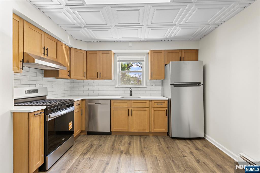 1534 Paterson Plank Road, Unit 2 Secaucus, NJ 07094 - Photo 8 of 17 a kitchen with a sink a refrigerator and cabinets