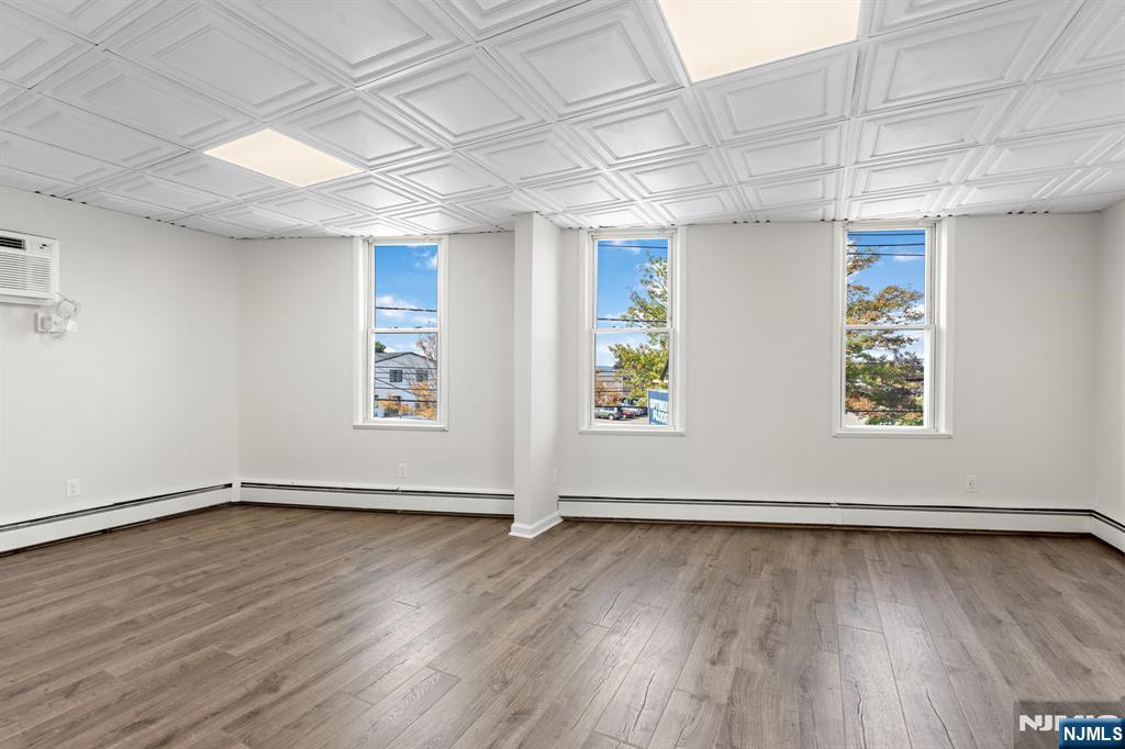 1534 Paterson Plank Road, Unit 2 Secaucus, NJ 07094 - Photo 9 of 17 an empty room with wooden floor and windows