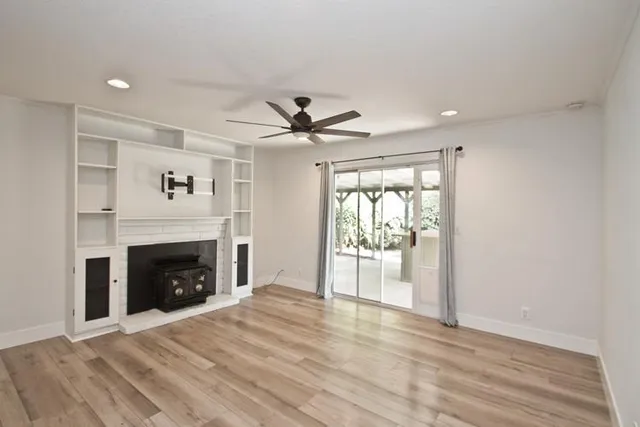 a view of an empty room with a fireplace and a window