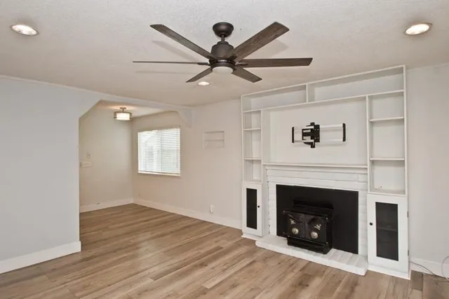 a view of a livingroom with a fireplace and a ceiling fan