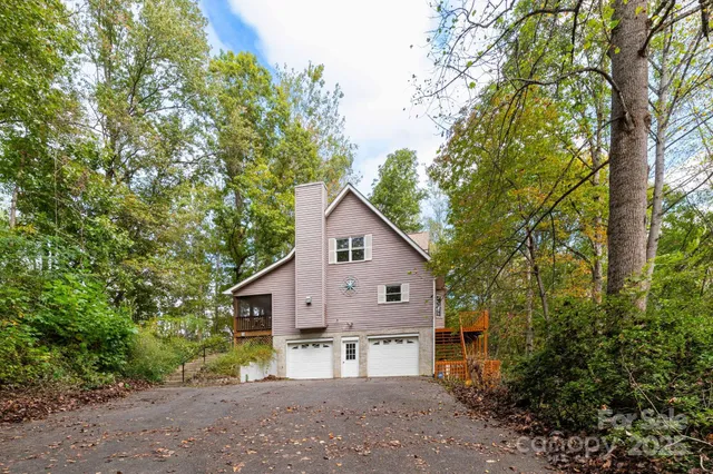a view of house with outdoor space and trees in the background
