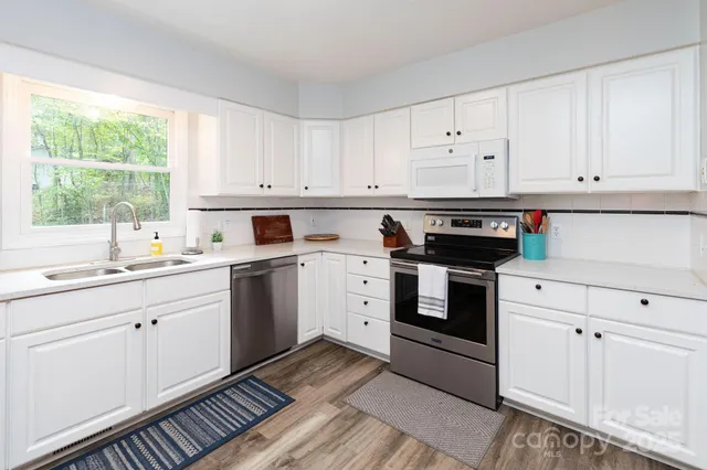 a kitchen with white cabinets and white appliances