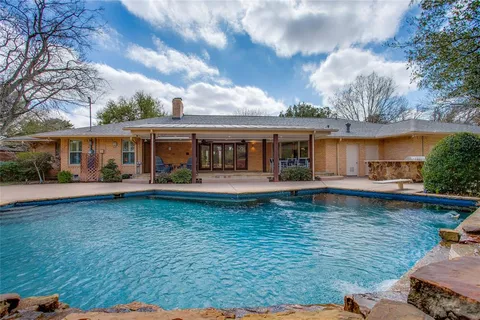 a view of a house with swimming pool and a yard