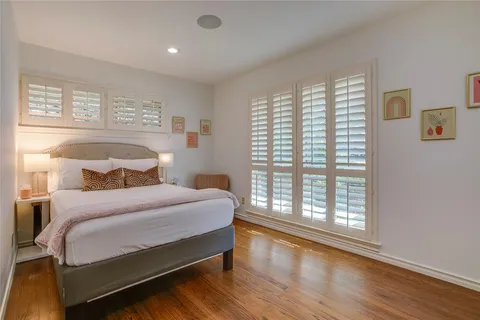a bedroom with a large bed and wooden floor