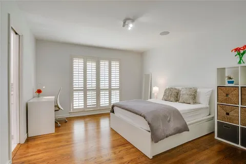 a bedroom with a large bed and a wooden floor