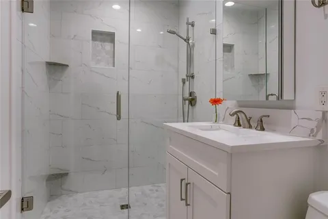 a bathroom with a sink shower and a mirror