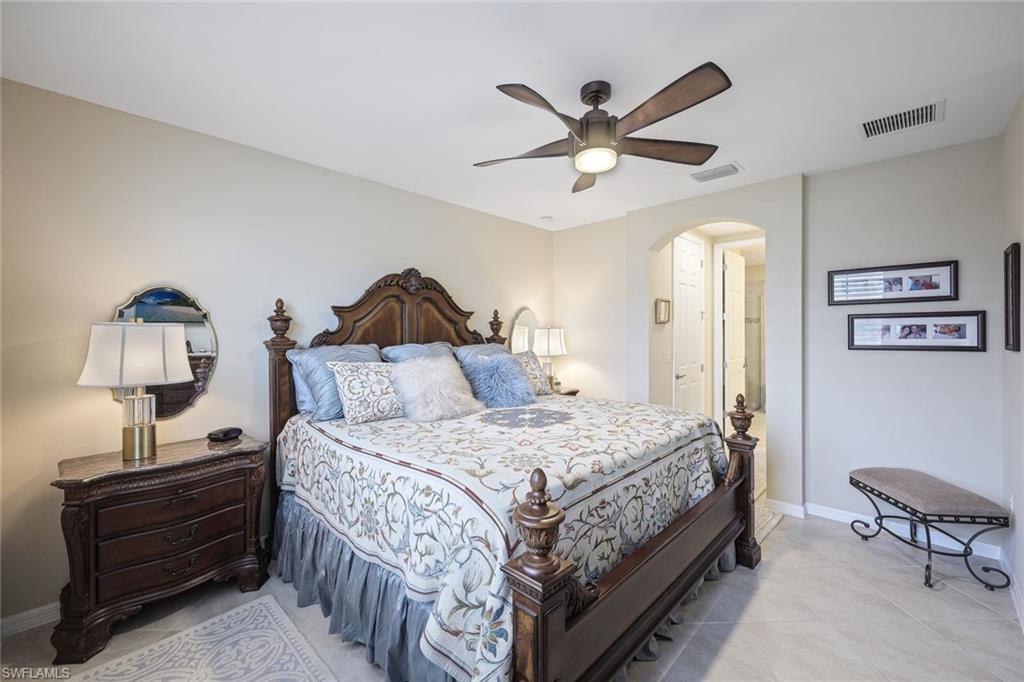 14822 Edgewater Circle Naples, FL 34114 - Photo 12 of 28 a bedroom with a bed and a chandelier