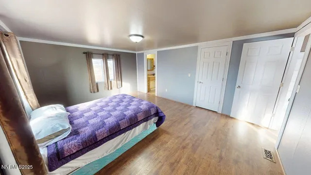 a bedroom with a bed and wooden floor