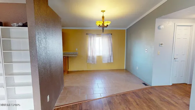 a view of a room with wooden floor closet and chandelier