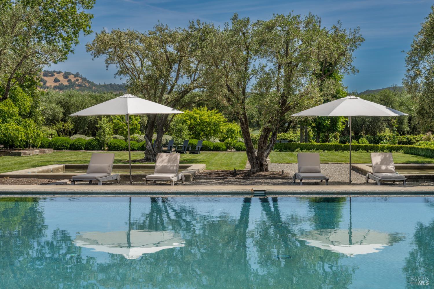 900 Rutherford Road St. Helena, CA 94574 - Photo 25 of 70 a view of a swimming pool with a table and chairs under an umbrella