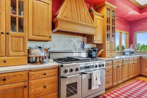 a living room with stainless steel appliances furniture a fireplace and a window