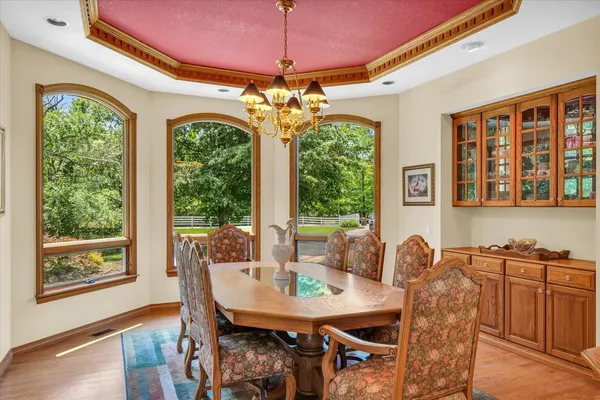 a dining room with furniture a chandelier and wooden floor