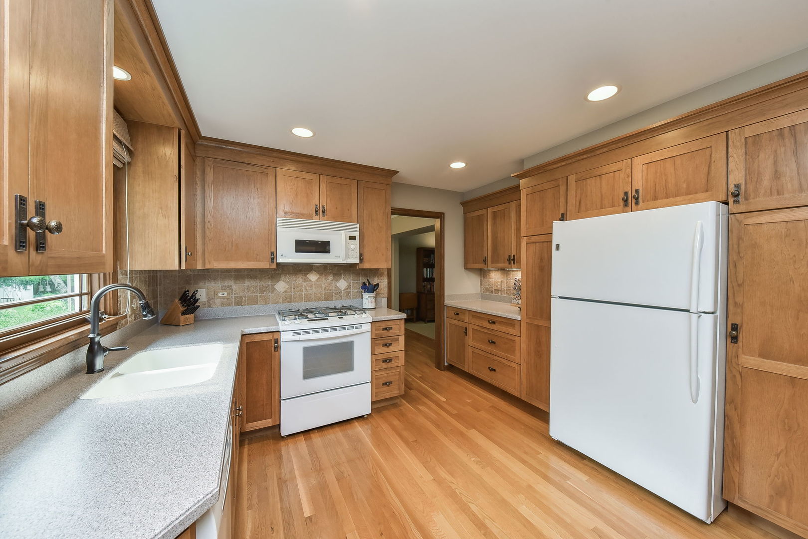 220 Aldrin Avenue Batavia, IL 60510 - Photo 5 of 23 a kitchen with a refrigerator a stove top oven a sink and dishwasher with wooden floor