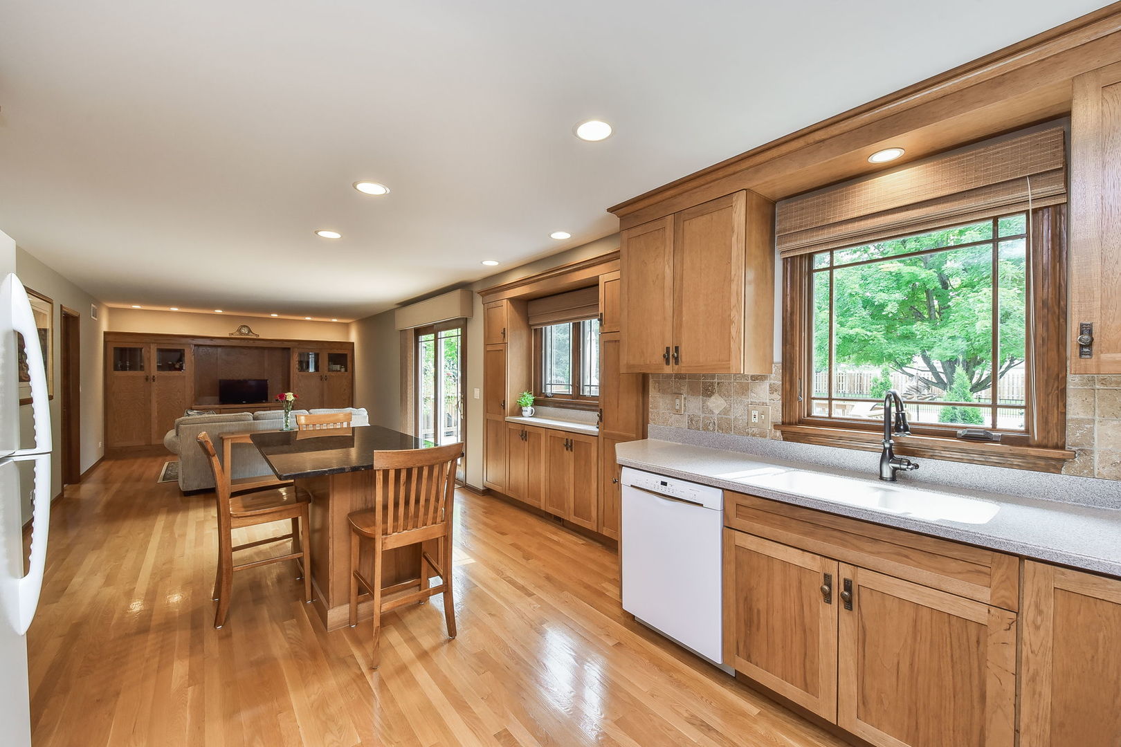 220 Aldrin Avenue Batavia, IL 60510 - Photo 7 of 23 a kitchen with stainless steel appliances granite countertop a stove a sink dishwasher a microwave oven and a dining table with wooden floor