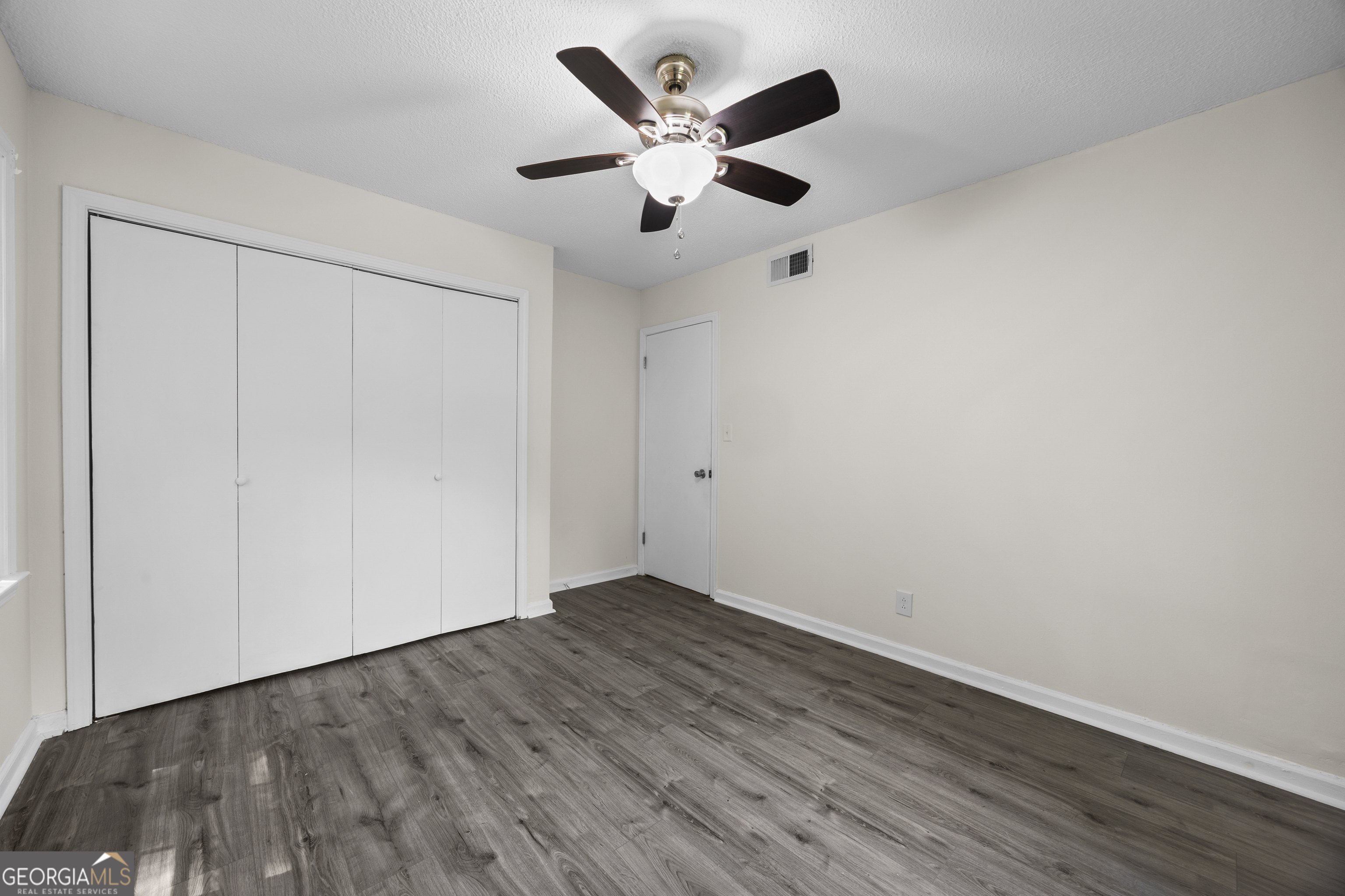135 Hill Street, Unit 22 Decatur, GA 30030 - Photo 18 of 36 an empty room with wooden floor and ceiling fan