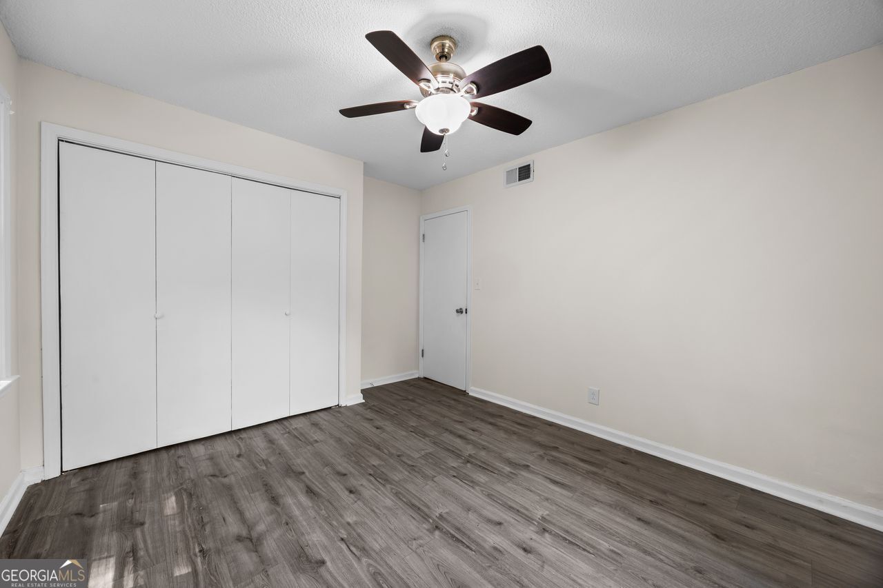 135 Hill Street, Unit 22 Decatur, GA 30030 - Photo 35 of 36 an empty room with wooden floor and ceiling fan
