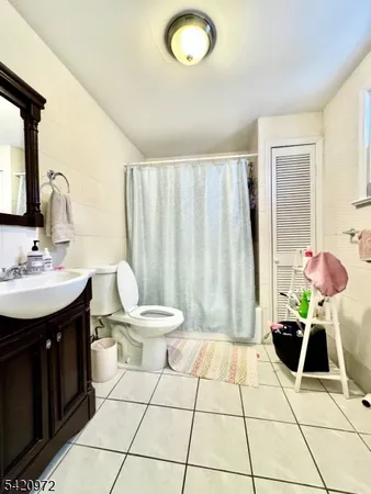 a bedroom with a bed a dresser and window