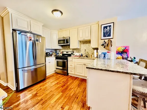 a kitchen with stainless steel appliances white cabinets and a stove top oven