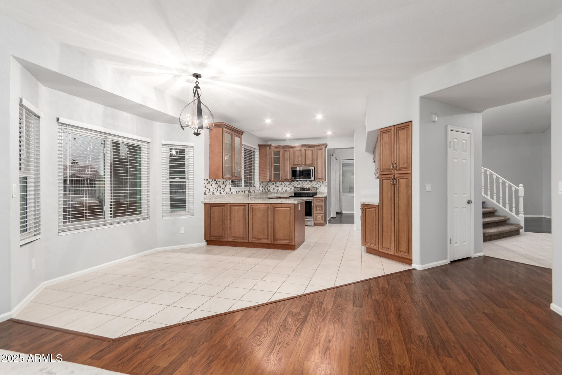 518 South Pueblo Street Gilbert, AZ 85233 - Photo 14 of 50 a large kitchen with kitchen island a stove a refrigerator a sink dishwasher with a dining table and wooden floor