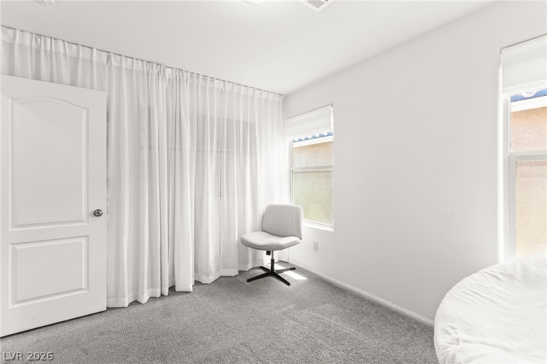 6435 Point Isabel Way Las Vegas, NV 89122 - Photo 35 of 57 A well-lit bedroom with ample space, featuring soft carpet flooring and a single window.