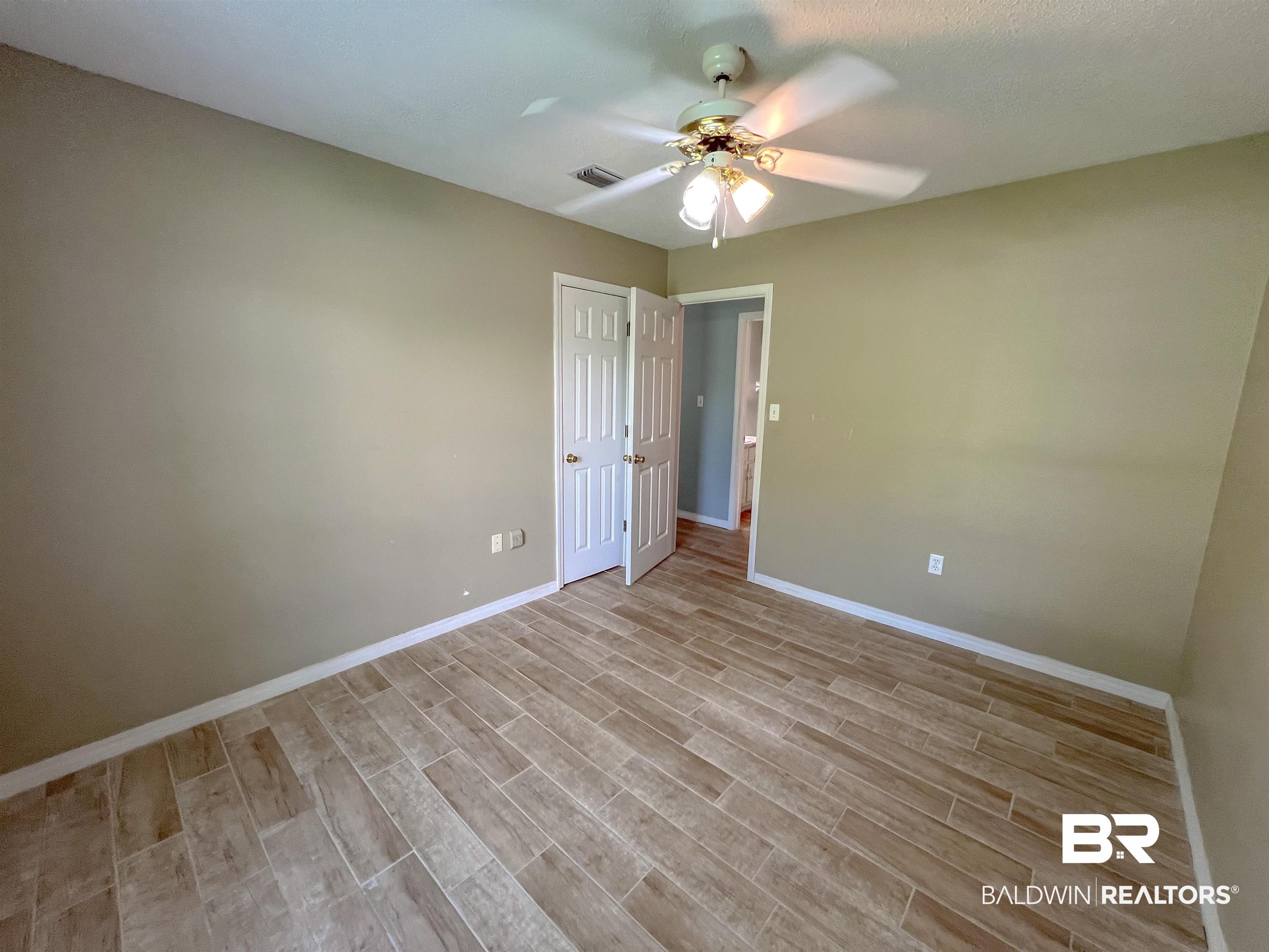1200 South Juniper Street Foley, AL 36535 - Photo 8 of 23 Empty room featuring light hardwood / wood-style floors and ceiling fan