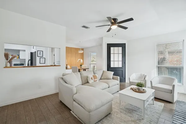 a living room with furniture and a wooden floor