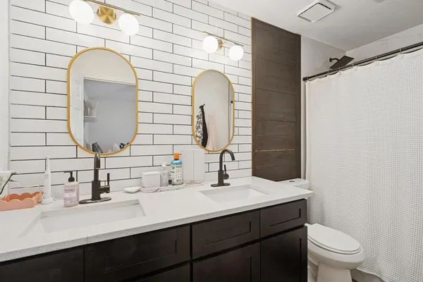 a bathroom with a double vanity sink mirror and toilet