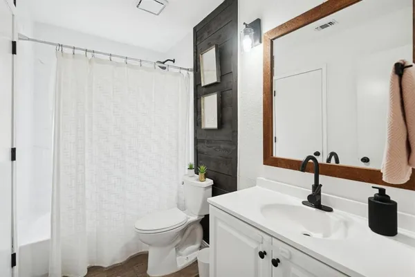 a bathroom with a sink a toilet and a mirror
