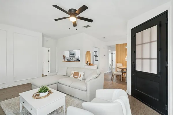 a living room with furniture a ceiling fan and a table