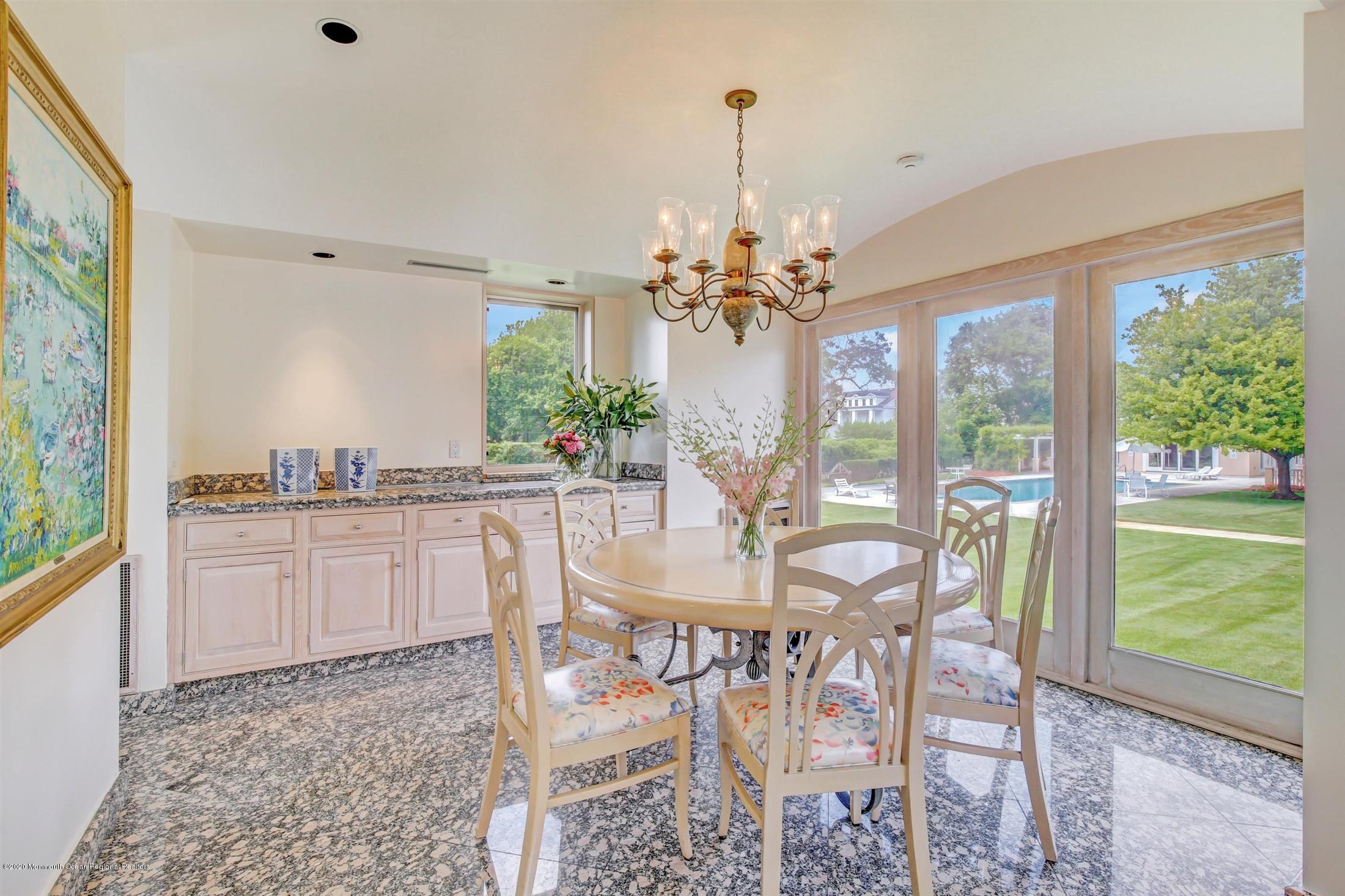 45 Runyan Avenue Deal, NJ 07723 - Photo 24 of 60 a dining room with wooden floor a chandelier a glass table and chairs