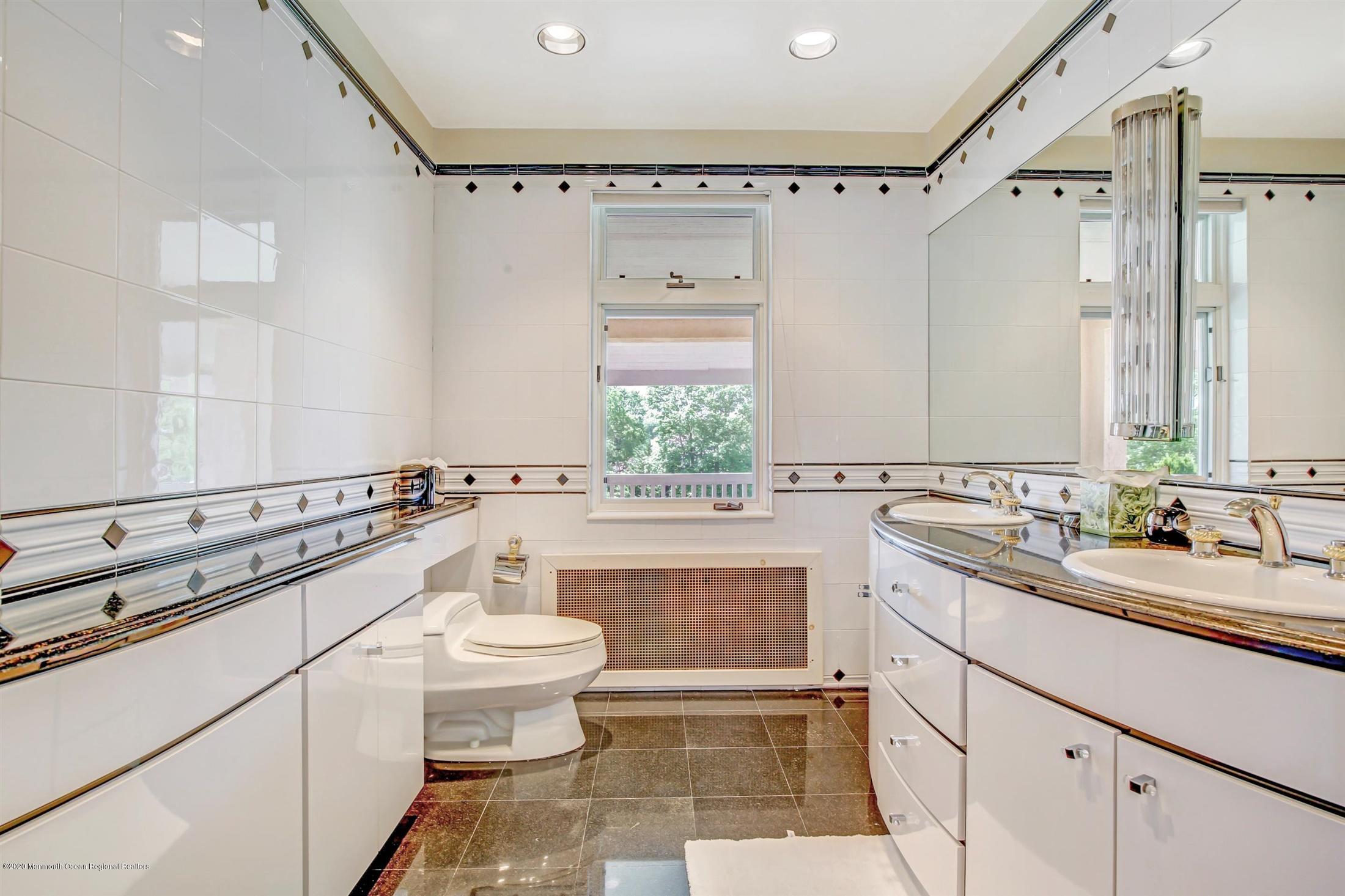 45 Runyan Avenue Deal, NJ 07723 - Photo 38 of 60 a bathroom with a sink a toilet a mirror and shower