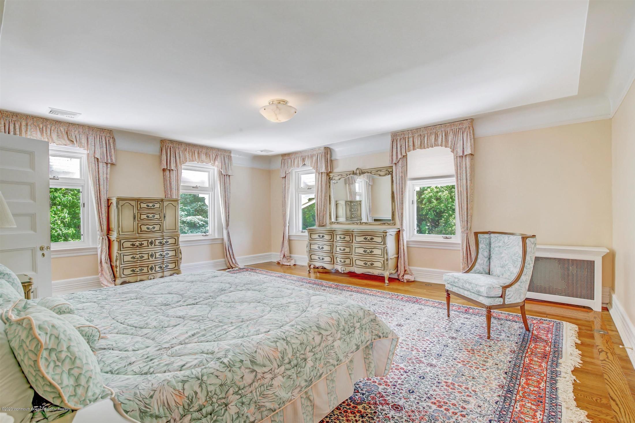 45 Runyan Avenue Deal, NJ 07723 - Photo 40 of 60 a spacious bedroom with a bed a table and chair