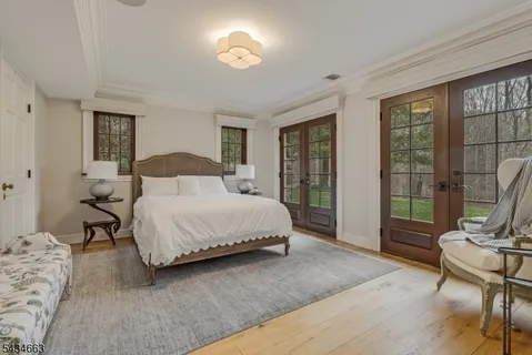 a bedroom with a bed and large windows