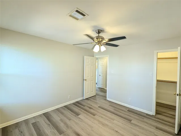 an empty room with a window and wooden floor