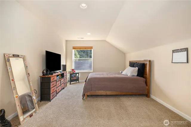 a spacious bedroom with a bed and a flat screen tv