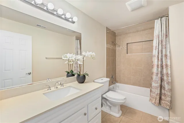 a bathroom with a granite countertop sink toilet a large mirror a shower and vanity