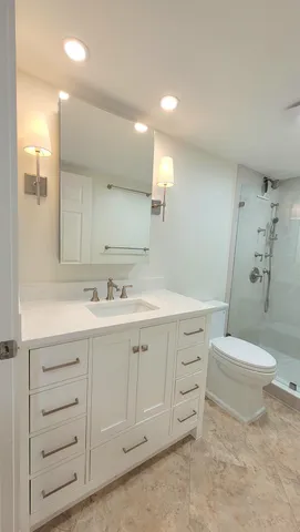 a spacious bathroom with a double vanity sink a toilet and a mirror