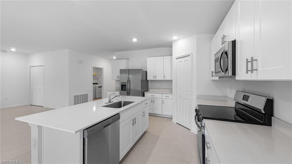 3717 23rd Street Southwest Lehigh Acres, FL 33976 - Photo 15 of 26 a kitchen with stainless steel appliances a sink stove and refrigerator