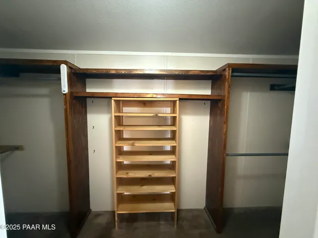 a view of walk in closet with empty racks