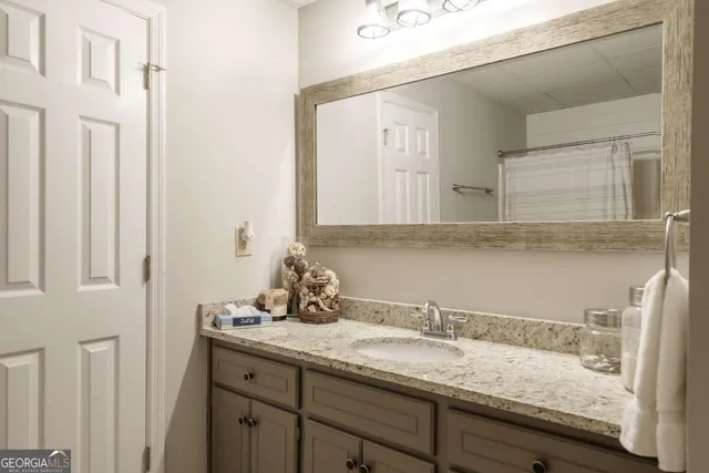 a bathroom with a granite countertop sink and a mirror