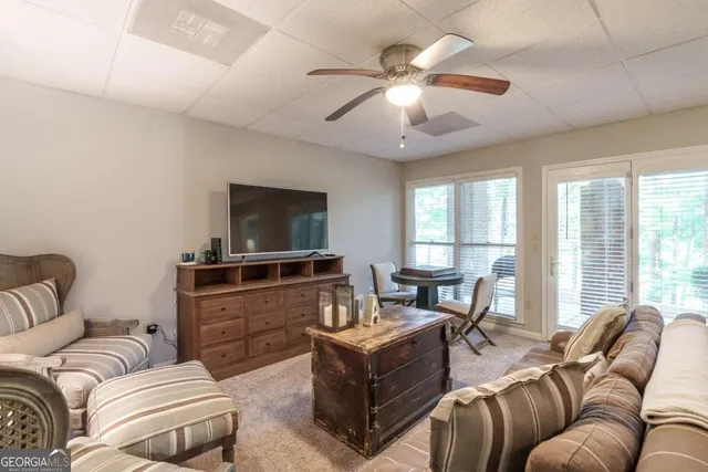 a living room with furniture a large window and a flat screen tv