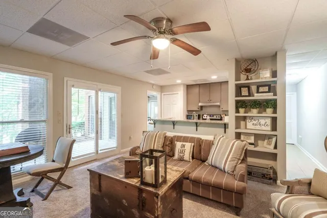 a living room with furniture kitchen view and a large window