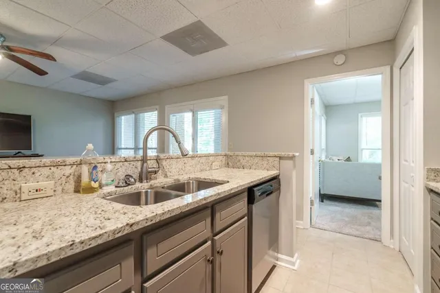 a en suite bathroom with a granite countertop sink and a mirror
