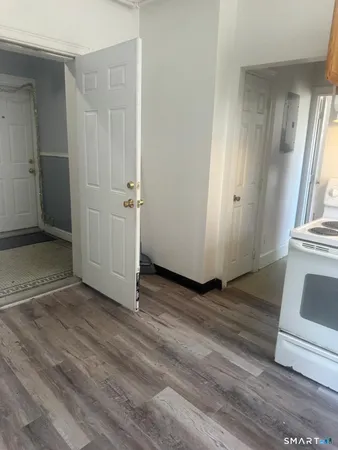 an empty room with wooden floor and entrance