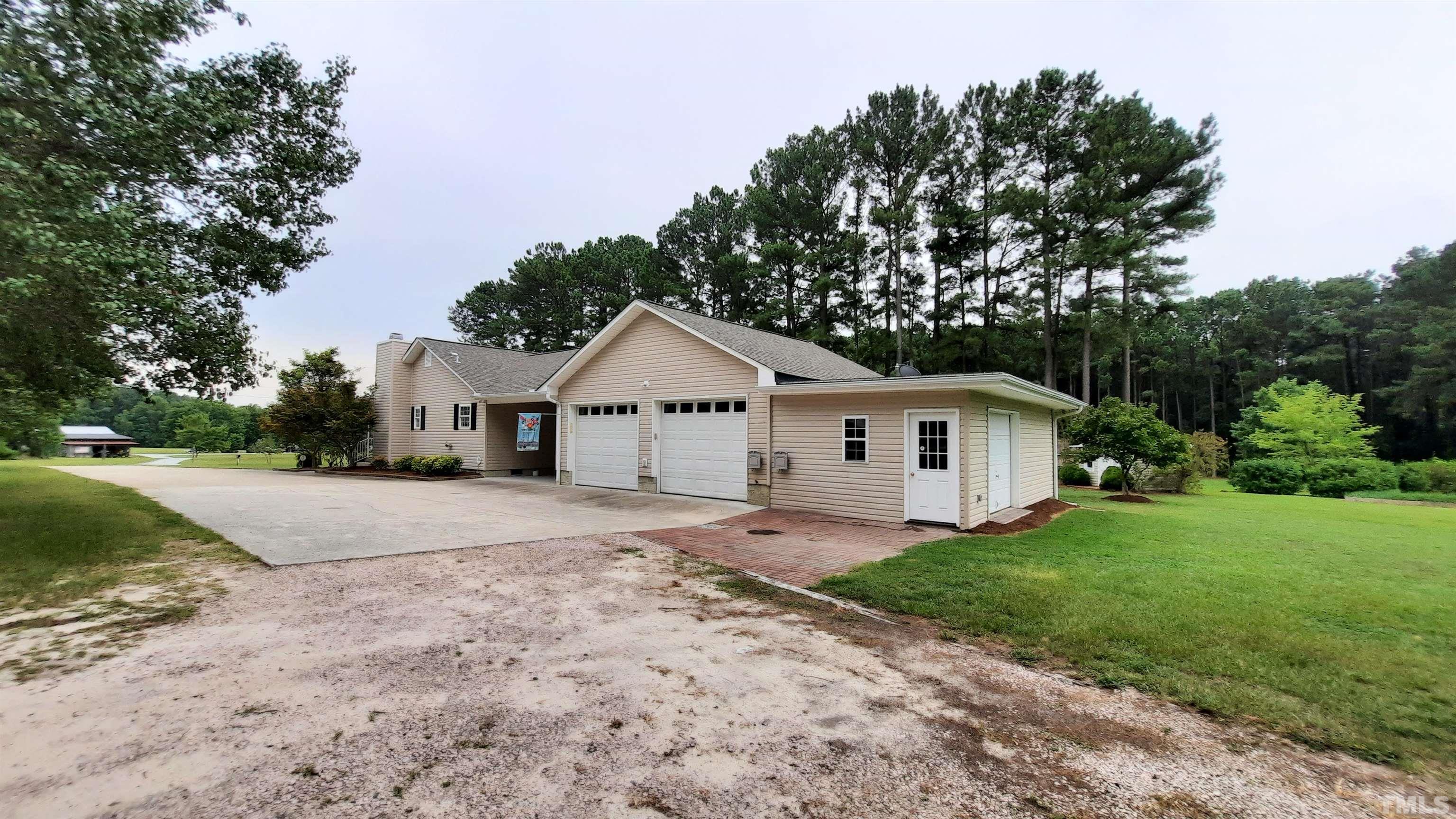 1909 Shaw Road Durham, NC 27704 - Photo 8 of 18 a front view of a house with a yard and garage