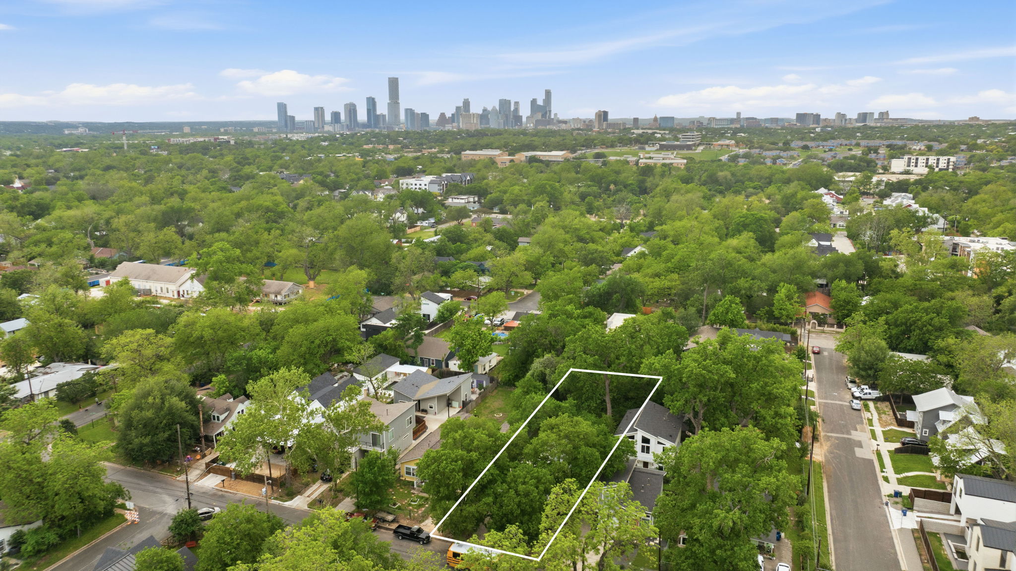 1122 Gunter Street Austin, TX 78702 - Photo 20 of 23 Aerial view showcasing the property's location within a verdant neighborhood, featuring a distant city skyline